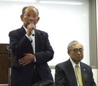 勝利感に満ちた裁判報告会であいさつする北原事務局長　右は葉山岳夫弁護士